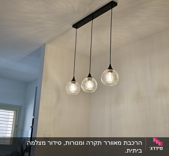 שלושה גופי תאורה תלויים מהתקרה